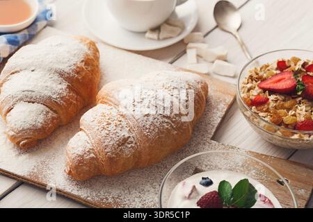 Croissant appena sfornati e piatti da colazione pronti per un pasto mattutino con caffè Foto Stock