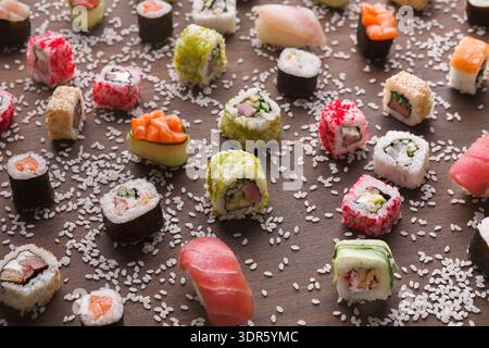 Collezione di sushi su superficie in legno con diversi tipi e colori disposti in stile mosaico Foto Stock