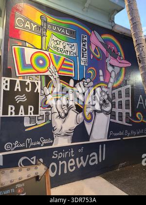 SOLO A USO EDITORIALE - KEY WEST FLORIDA: Un vivace murale di Street art intitolato "Spirit of Stonewall" situato sul lato del Bourbon Bar 801 all'angolo tra Duval e Petronia Street a Key West, Florida. L'opera d'arte di Lisa Marie Kish presenta motivi arcobaleno, il cartello "i Love You" in ASL, uno stiletto rosa con tacco alto e riferimenti alle rivolte di Stonewall del 1969 e alla liberazione gay. Primo piano di un grande murale all'aperto che celebra la storia e la cultura LGBTQ+ a Key West, Florida. Il dipinto include iconiche immagini locali come il cartello di Duval Street e il famoso stiletto di Capodanno, Symbolizin Foto Stock