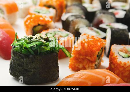 Sushi Rolls freschi e Nigiri disposti su un piatto con colori brillanti e diversi condimenti Foto Stock