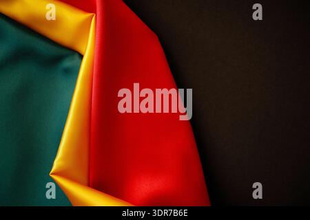 Onde di seta di colore pan africano su sfondo nero che celebrano il patrimonio e la libertà. Colori flag mese storia nero Foto Stock