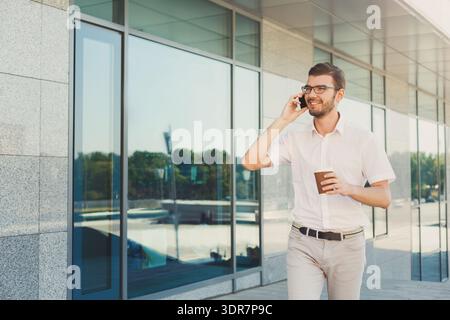 Collage di un uomo che cammina e parla su un telefono con la tazza di caffè in mano Foto Stock