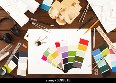 Raccolta di strumenti di progettazione e campioni di colore disposti su un'area di lavoro per un progetto creativo Foto Stock