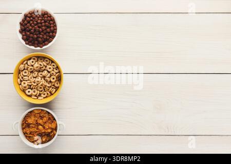 Raccolta di cereali da colazione disposti in ciotole su una superficie di legno Foto Stock