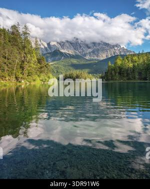 Vista sul lago Eibsee, le montagne Wetterstein con lo Zugspitze sullo sfondo, nuvole che si muovono attraverso le vette, Grainau, Garmisch-Partenki Foto Stock