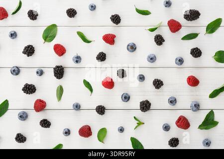 Frutta fresca e verdi disposti su una superficie di legno in un layout colorato Foto Stock