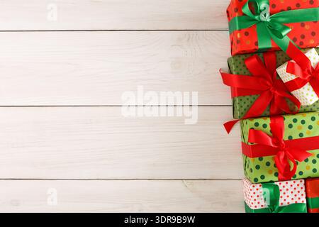 Collezione di regali avvolti in vari colori su una superficie in legno durante le festività Foto Stock