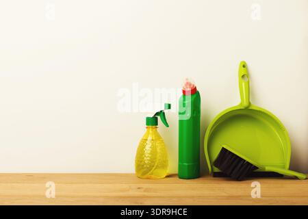 Materiali di consumo per la pulizia disposti su un tavolo di legno in una configurazione semplice per le attività di manutenzione domestica Foto Stock