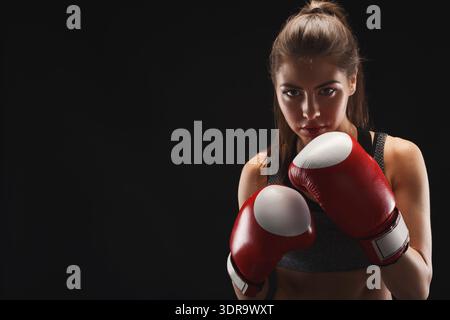 Sessione di pratica di pugilato con una donna in guanti rossi che si prepara a spar Foto Stock