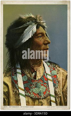 Questa cartolina fotografica a colori in bianco e nero del 1903 circa mostra il capo Ojibwa Obtossaway di profilo, con un cappello di pelliccia con piume, un colletto con perline, un cinturino e una camicia a cuoio con frangia. L'immagine documenta l'abbigliamento indigeno, l'ornamento, l'abbigliamento cerimoniale e l'artigianato tradizionale del popolo Ojibwa nel Wisconsin, Stati Uniti. La cartolina conserva testimonianze storiche della leadership, dell'abbigliamento e dell'identità culturale dei nativi americani all'inizio del XX secolo. Foto Stock