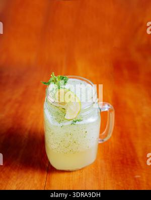 Rinfrescante limonata con menta su tavolo in legno. Bevanda limonata su fondo di legno Foto Stock