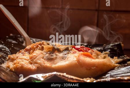 Un tradizionale Nacatamal servito al momento. Vista laterale del tradizionale Nacatamal servito su foglie di banana, primo piano del Nacatam nicaraguense Foto Stock