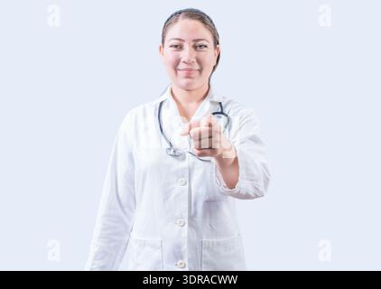 Medico sorridente che punta verso la telecamera. Un medico felice che ti indica, un giovane medico che ti indica Foto Stock