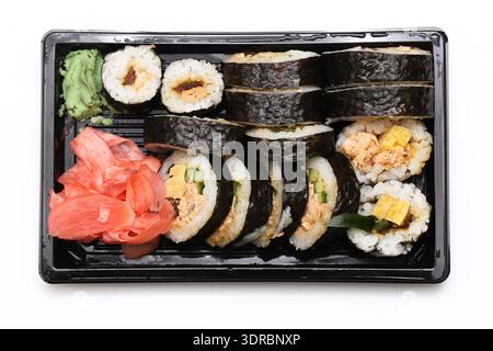 Panini di sushi in un contenitore da asporto. Assortimento di piatti giapponesi con zenzero e wasabi. Cucina asiatica fresca. Foto Stock