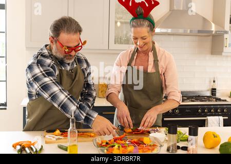 Periodo natalizio, coppia matura che prepara il pasto natalizio in cucina, a casa Foto Stock