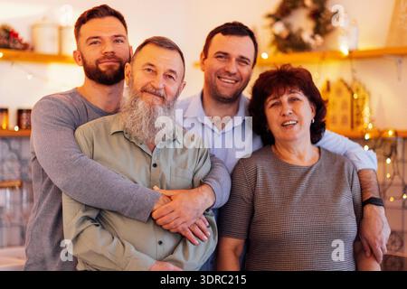Un ritratto ravvicinato dei genitori maturi e dei loro figli adulti. La madre sorridente, il padre e i loro figli attraenti sono a casa Foto Stock