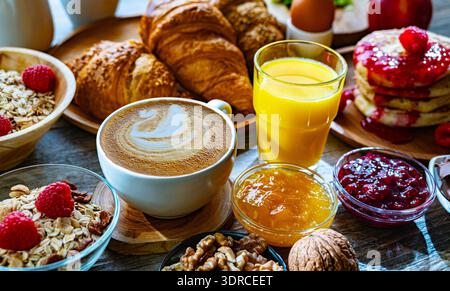 La colazione è servita con caffè, succo d'arancia, pancake e croissant Foto Stock