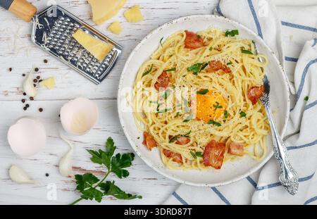 Pasta carbonara. Spaghetti con pancetta, uova, prezzemolo e salsa al parmigiano in un piatto bianco su una Foto Stock