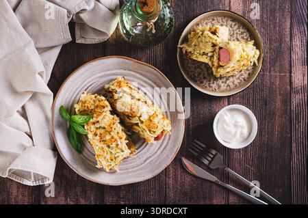 Salsicce avvolte in pancake di cavolo tritati su un piatto con vista dall'alto Foto Stock