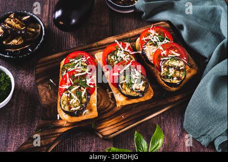 Bruschetta vegetariana con melanzane alla griglia, pomodori e formaggio su un tavolo Foto Stock
