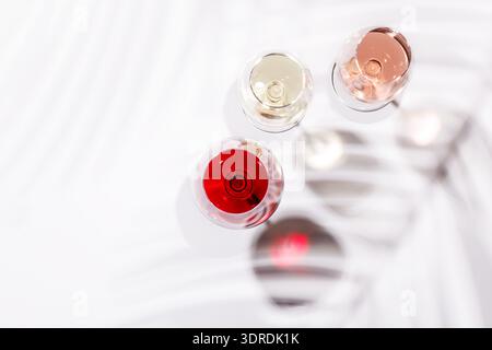 Tre bicchieri da vino pieni di vino rosso, bianco e rosa Foto Stock