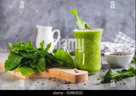 Frullato rinfrescante a base di foglie di riccio e semi di lino in un bicchiere sul tavolo Foto Stock
