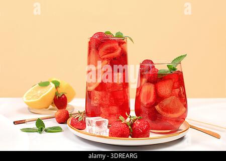 Strawberry Iced Tea o Mint Lemon cocktail è una rinfrescante ricetta estiva di bevande. Bicchieri con limonata di frutti di bosco su una base leggera Foto Stock