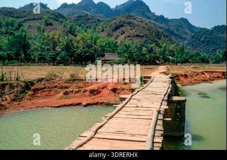 Eingescanntes Di,einer historischen Farbaufnahme eines Holzstegs über einen Fluß in Vietnam Foto Stock