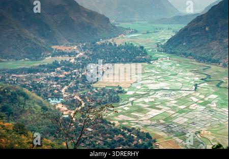 Eingescanntes Diorgov einer historischen Farbaufnahme von gewässerten Reisfeldern mit Siedlung in Vietnam aus der Vogelperspektive Foto Stock