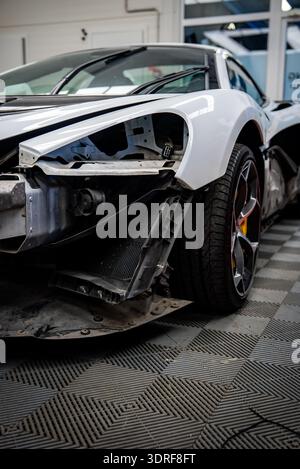 Smontaggio anteriore sinistro McLaren bianco in officina, radiatore esposto Foto Stock