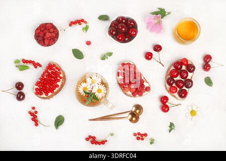 Colazione sana con ingredienti e tè alle erbe con camomilla. Mini panini alla frutta dietetica con morbido formaggio fresco Foto Stock