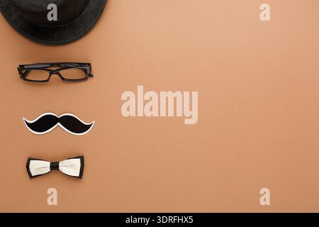 Accessori per una festa con occhiali da baffi e cravatta con fiocco su sfondo marrone Foto Stock