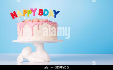 Una torta di compleanno natalizia con candele colorate Foto Stock