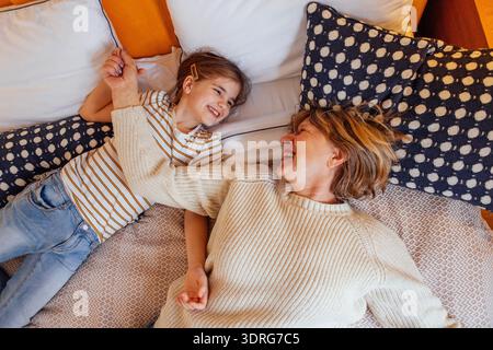 Una donna anziana e la sua dolce nipote si stanno divertendo sul letto Foto Stock