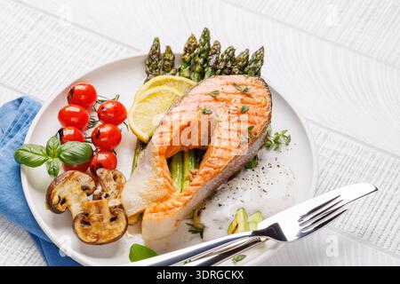 Bistecca di salmone grigliata su asparagi grigliati, un pasto delizioso Foto Stock