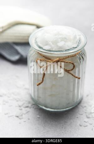 Scaglie di magnesio in vaso di vetro per un bagno rilassante con asciugamani Foto Stock