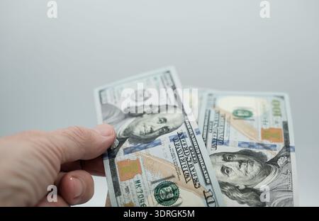 Mano umana con dollari piegata in modo casuale. Affrettati nelle transazioni valutarie, nei rischi finanziari. Profitto o perdita di denaro. Profondità di campo ridotta. Foto Stock