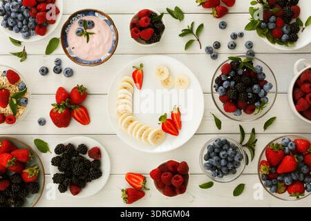 Raccolta di frutta fresca e yogurt disposti su un tavolo per uno spuntino sano Foto Stock