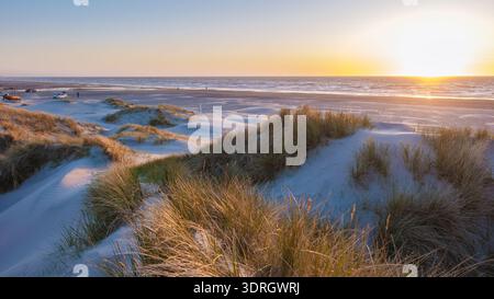 Splendido tramonto sulle dune di sabbia in una spiaggia tranquilla in Danimarca con onde dolci Foto Stock