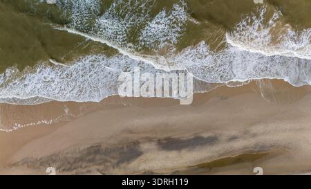 Serena vista aerea della spiaggia sabbiosa di Denmarks e delle dolci onde sotto il sole di mezzogiorno Foto Stock