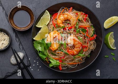 Gamberetti e verdure, funchoza, spaghetti di riso neri nella ciotola, vista dall'alto Foto Stock