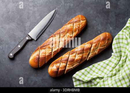 Fette di pane e il coltello sulla pietra scura tabella. Vista da sopra Foto Stock