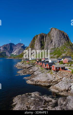 Splendida vista costiera delle tradizionali cabine rosse vicino ai fiordi in Norvegia in una giornata limpida e soleggiata Foto Stock