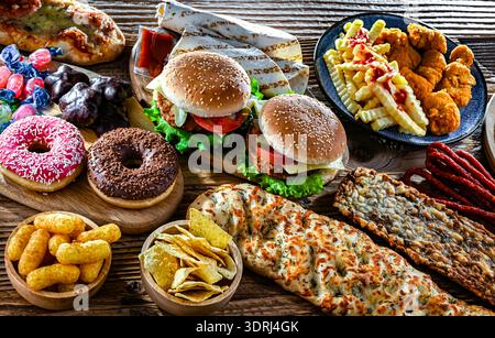 Alimenti che aumentano il rischio di cancro. Cibo spazzatura Foto Stock