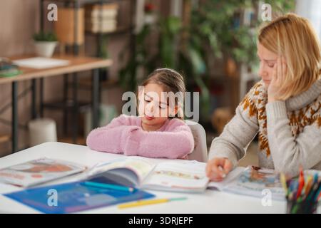 Madre e figlio stanchi che lottano con i compiti a casa Foto Stock