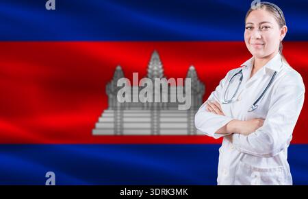 Medico donna sulla bandiera della Cambogia. Medico con le braccia incrociate sulla bandiera della Cambogia. Concetto di salute e assistenza in Cambogia Foto Stock