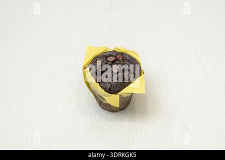 Un vassoio di muffin di vari gusti, mostrando variazioni di colore della pastella, dal marrone cioccolato al giallo vaniglia alle bacche rossastre Foto Stock