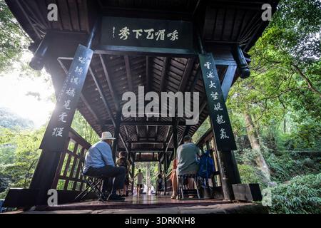 Persone che si rilassano sul ponte Huyu, Emeishan, prefettura di Leshan, Sichuan, Repubblica Popolare Cinese, Asia Foto Stock