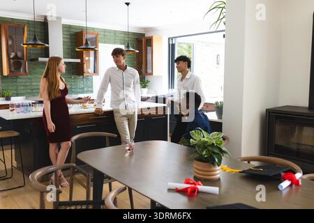 A scuola, amici adolescenti che festeggiano la laurea, chiacchierano e trascorrono del tempo insieme. festeggiamenti, amicizia, adolescenti, felicità, Foto Stock
