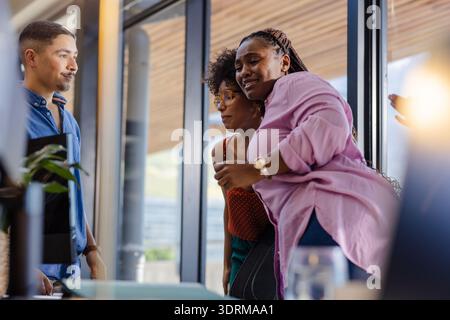 Colleghi in ufficio che condividono momenti di gioia durante una riunione di lavoro informale. Lavoro di squadra, collaborazione, lavoro di squadra, brainstorming, tè Foto Stock